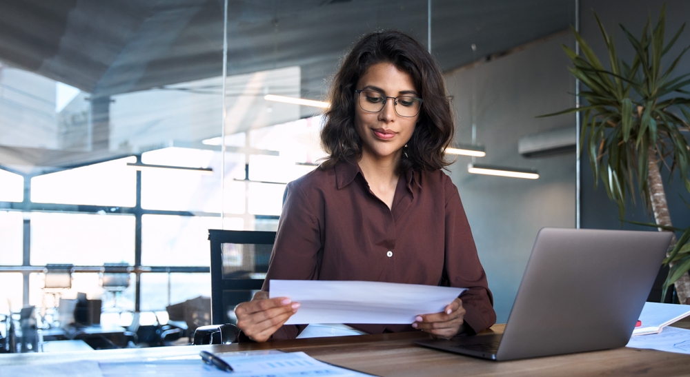 Professional woman reviewing financial documents for an asset depletion mortgage loan in California.