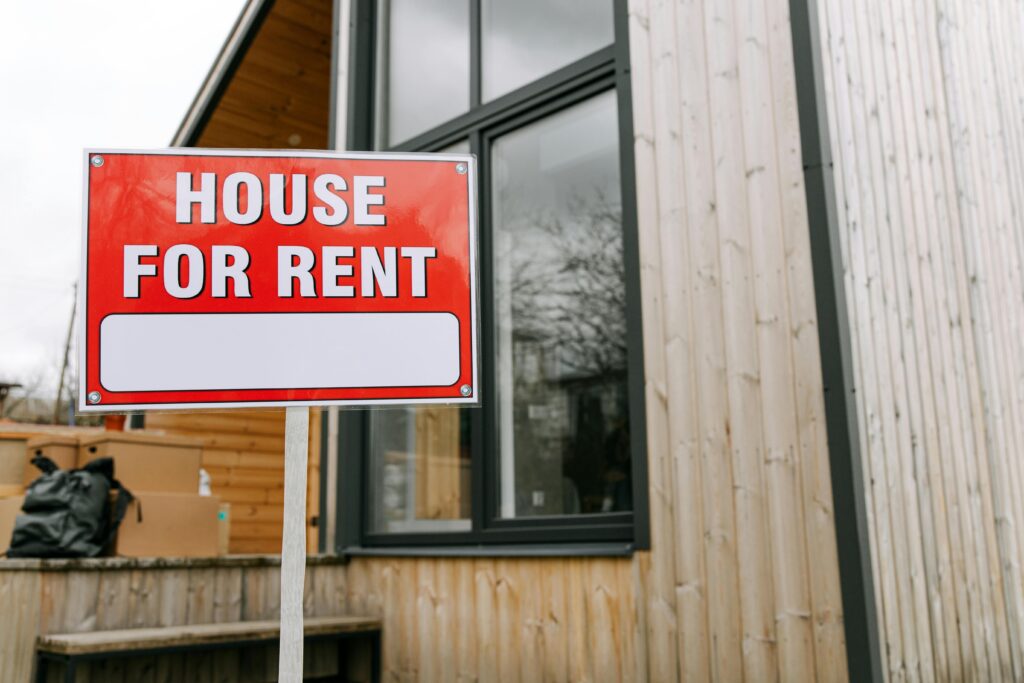 Red House for Rent sign in front of modern wooden investment property