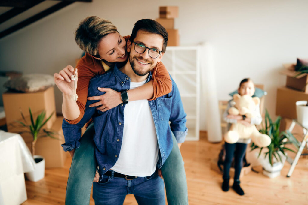 Happy family celebrating new home purchase with keys in hand.