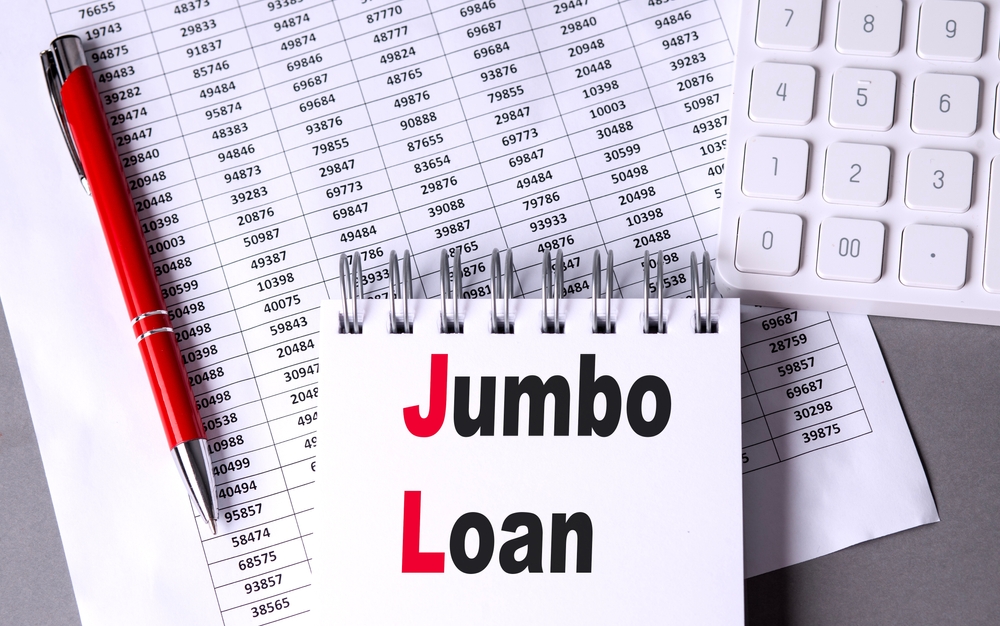 Jumbo loan paperwork with calculator and pen representing mortgage lending.